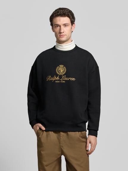 Männermodel trägt Sweatshirt mit Logo-Print von POLO RALPH LAUREN, schwarz, Motiv-Print, Rundhals, Langarm, Baumwollmix, Ganzkörperansicht von vorne.