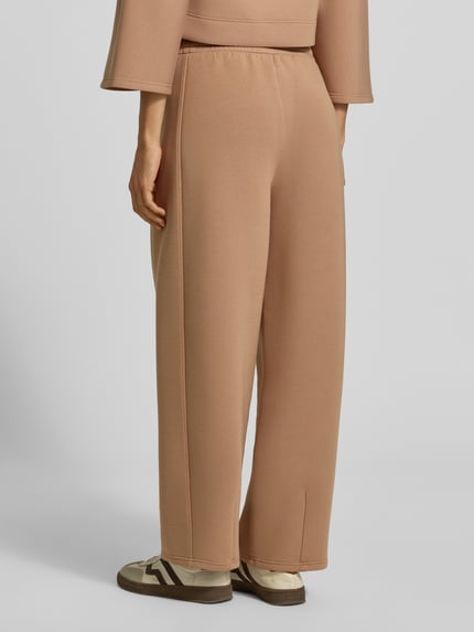 Vrouwenmodel draagt Wide Leg Sweathose aus Modal-Mix model 'GETTO' van Weekend Max Mara in lichtbruin met zachte textuur, volledige lichaam achteraanzicht.