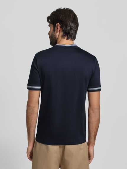 Männermodel trägt Slim Fit T-Shirt aus reiner Baumwolle Modell 'TESSLER 202' von BOSS in Dunkelblau, unifarben, Rückansicht.