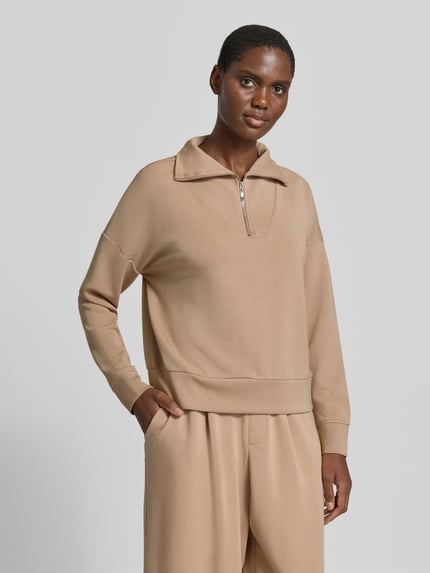 Frauenmodel trägt Troyer mit Stehkragen und Reißverschluss von Christian Berg Woman in Beige, Material-Mix mit Modal-Anteil, Regular Fit, Ganzkörperansicht von vorne.