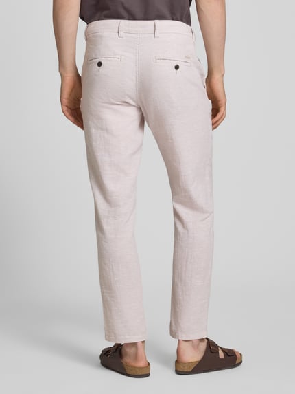 Männermodel draagt Tapered Fit Hose met steekzakken model 'STACE' van Jack & Jones in lichte kleur, katoenmix, productdetails volgens context, volledige lichaamsweergave achteraan.