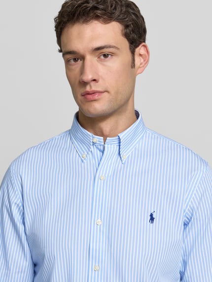 Männermodel trägt Freizeithemd mit Knopfleiste von Polo Ralph Lauren aus Baumwoll-Elasthan-Mix, Regular-Fit, Label-Stitching, Nahaufnahme Oberkörper.