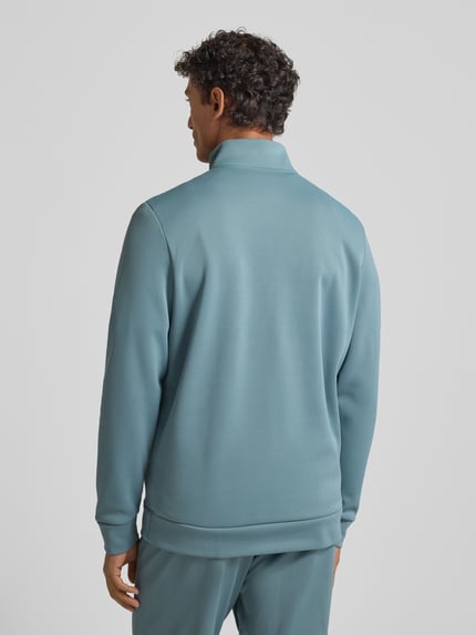Männermodel trägt Sweatshirt mit Label-Detail van Under Armour in lichtblauw met ribgebreide boorden, losse pasvorm, rugaanzicht, Ganzkörperansicht Rückansicht.