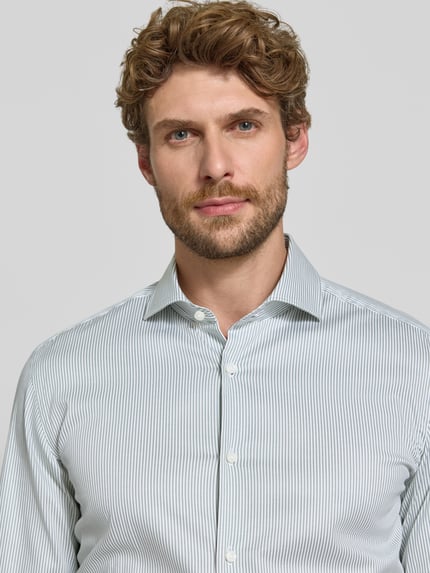Männermodel trägt Slim Fit Businesshemd aus Baumwoll-Mix Modell 'HANK' von BOSS, feine Streifen in Hellgrau und Weiß, Nahaufnahme Oberkörper, Herren Businesshemd von BOSS