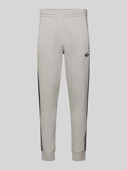 Produktfoto, Sweatpants mit elastischem Bund von adidas Originals aus Katoenmix, los model, labelstitching, steekzakken, binnenbeenlengte maat M 75 cm, melangegrijs met zwarte details