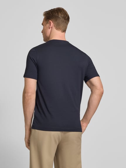 Männermodel trägt T-Shirt mit Label-Detail von bugatti in Dunkelblau, reine Baumwolle, gerader Schnitt, Rückenlänge 70 cm, Ganzkörperansicht Rückansicht.