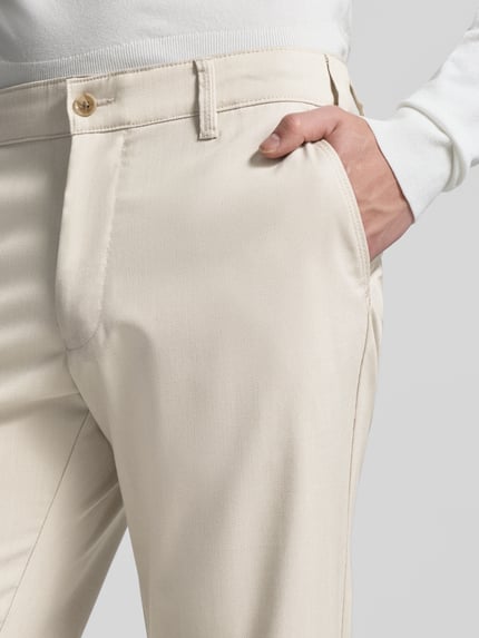 Mannenmodel draagt 'Stoffhose mit französischen Eingrifftaschen' van Christian Berg Men in beige met rechte snit en Franse steekzakken, detailopname.