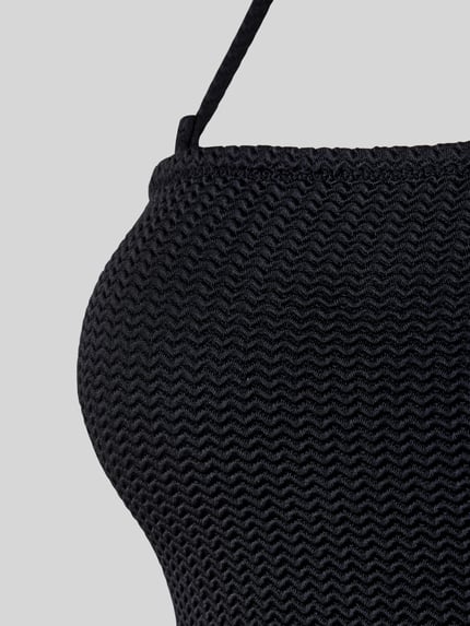 Vrouwenmodel draagt Body met Neckholder van Seafolly, zwart, structuurmateriaal met stretch, aansluitende pasvorm, detailopname.
