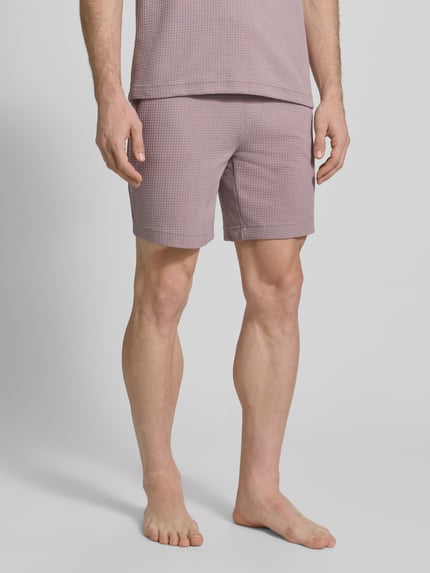 Mannelijk model draagt Regular Fit Sweatshorts uit katoenmix model 'AUSTIN' van HUGO, effen kleur, wafelstructuur, zijzakken, elastische tailleband, tunnelkoord, heren sweatshort, voorkant, dichtbij opname onderlichaam.
