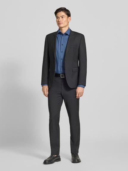 Männermodel trägt Regular Fit Businesshemd mit Kentkragen von OLYMP in Blau mit feinem Webmuster, Ganzkörperansicht von vorne.