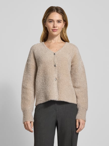 Vrouwenmodel draagt Strickjacke aus Effektgarn mit V-Ausschnitt Modell 'LISTRA' van YAS in beige, regular fit, voorkant geheel zichtbaar, context: materiaal-mix met viscose, knoopsluiting, lengte 53 cm, mouwlengte 54 cm. Ganzkörperansicht von vorne.