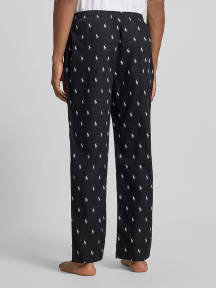 Männermodel trägt schwarze Regular Fit Pyjama-Hose aus reiner Baumwolle von Polo Ralph Lauren Underwear, weißes Muster, Ganzkörperansicht Rückansicht.