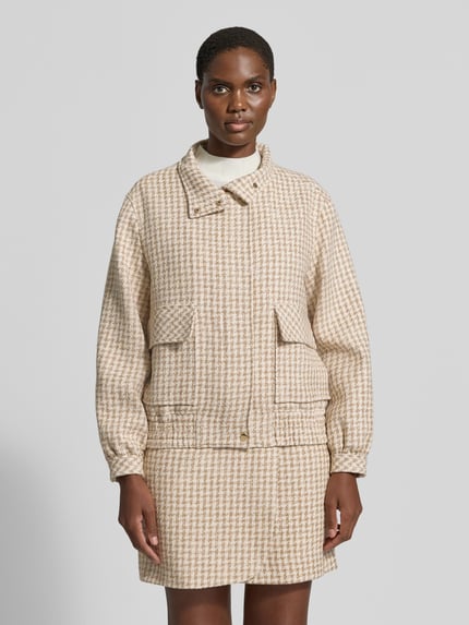 Frauenmodel trägt Jacke im Allover-Look mit Pattentaschen von Marc Cain, Baumwoll-Mix, beige-weißes Muster, Ganzkörperansicht von vorne.