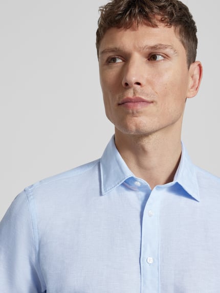 Männermodel trägt Slim Fit Freizeithemd aus Leinen-Mix von Jake*s in Hellblau, Kentkragen, Knopfleiste, Nahaufnahme Oberkörper.