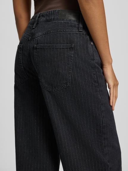 Frauenmodel trägt Regular Fit Jeans Wide Fit mit Bundfalte von MOP DENIM, dunkelblaue, matte Denim-Optik mit Nadelstreifen, 5-Pocket-Design, Detailaufnahme Rückansicht.