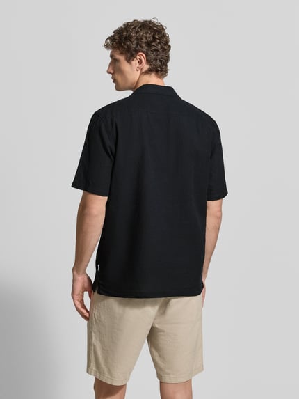 Männermodel trägt Relaxed Fit Freizeithemd aus Leinen-Baumwoll-Mix von Lindbergh in Schwarz, Reverskragen, Knopfleiste, Rückenlänge 76 cm, Schulterbreite 47 cm, Ärmellänge 25 cm, Ganzkörperansicht Rückansicht.