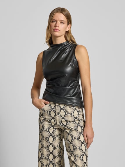 Vrouwenmodel draagt Top in leerlook met plooien Model 'DANDY' van Noisy May, nauw aansluitend model, asymmetrische look, ruglengte maat S 54 cm, Ganzkörperansicht van voren.