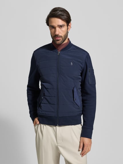 Mannenmodel draagt Sweatjack met geribde boorden van Polo Ralph Lauren, regular fit, opstaande kraag, ritssluiting, labelstitching, drukknoopzakken, ruglengte 57 cm, mouwlengte 70 cm, kleur donkerblauw, voorkant, nahaufnahme bovenlichaam.