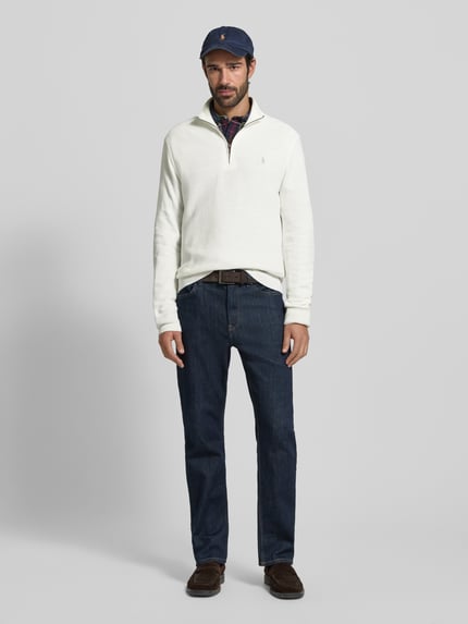 Männermodel trägt Regular Fit Troyer mit Label-Stitching von Polo Ralph Lauren aus reiner Baumwolle in Weiß, Gerippte Abschlüsse, Troyer-Kragen, kurzer Reißverschluss, Rückenlänge 70 cm, Ärmellänge 68 cm, Ganzkörperansicht von vorne.