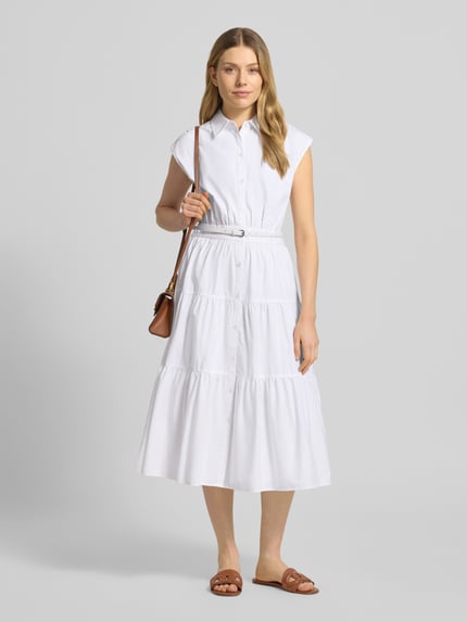 Frauenmodel trägt Hemdblusenkleid mit Gürtel und Knopfleiste von MICHAEL Michael Kors in Weiß, reine Baumwolle, tailliert, Ganzkörperansicht von vorne.