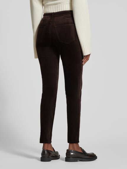 Frauenmodel trägt Slim Fit Hose mit Samtoptik von Marc O'Polo, dunkelbraune Farbe, strukturierte Oberfläche, 5-Pocket-Design, Ganzkörperansicht Rückansicht.