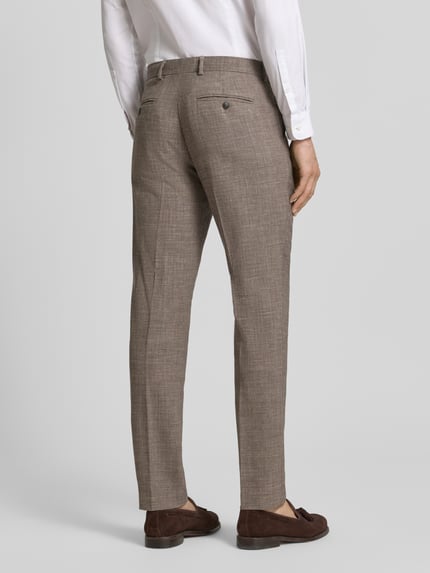 Männermodel trägt Slim Fit Anzughose mit Woll-Anteil Modell 'SLIM-OASIS' von SELECTED HOMME in Melange-Optik, Ganzkörperansicht Rückansicht.