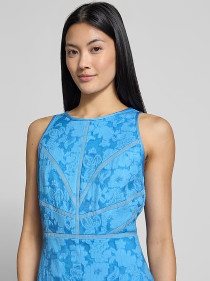 Kobiece modelka ma na sobie sukienkę midi z mieszanki wiskozy Model 'Lee' od Ted Baker, fason taliowany, kwiatowy wzór, bez rękawów, niebieski kolor, szerokość w rozmiarze 36: 33 cm, długość tyłu w rozmiarze 36: 124 cm, zbliżenie na górną część ciała