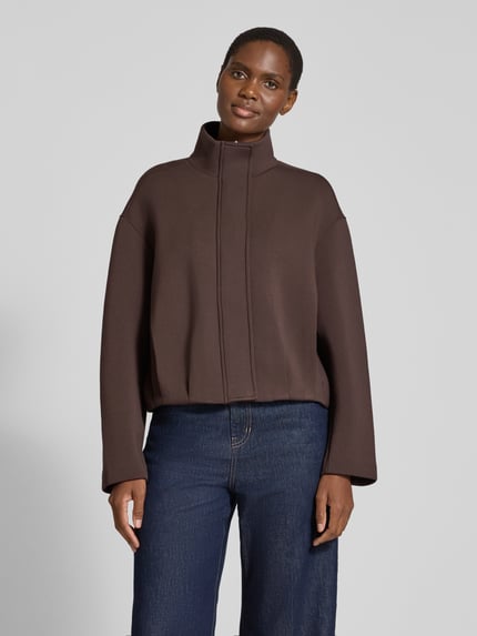 Frauenmodel trägt Kurzblazer mit verdeckter Knopfleiste von COMMA in Dunkelbraun, Viskose-Mix, Stehkragen, Regular Fit, Ganzkörperansicht von vorne.
