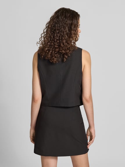 Frauenmodel trägt schwarze Regular Fit Anzugweste mit Viskose-Anteil Modell 'BOSELLA' von PIECES, glatte Struktur, Ganzkörperansicht Rückansicht.