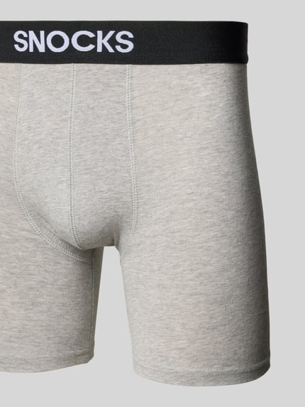 Männermodel trägt Boxershorts mit elastischem Label-Bund von Snocks in Grau, eng anliegend, gewachste-Baumwolle-Mix, Nahaufnahme Oberkörper.