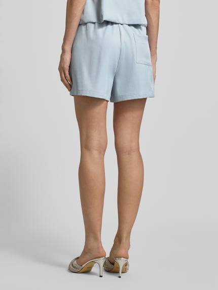Männermodel trägt Shorts mit Falten und Eingrifftasche von Little Mistress, materiał z domieszką stretchu, krój regular fit, jasno niebieski, szerokość w rozmiarze 36: 35 cm, długość nogawki wewnętrznej: 10 cm, widok całej sylwetki z tyłu