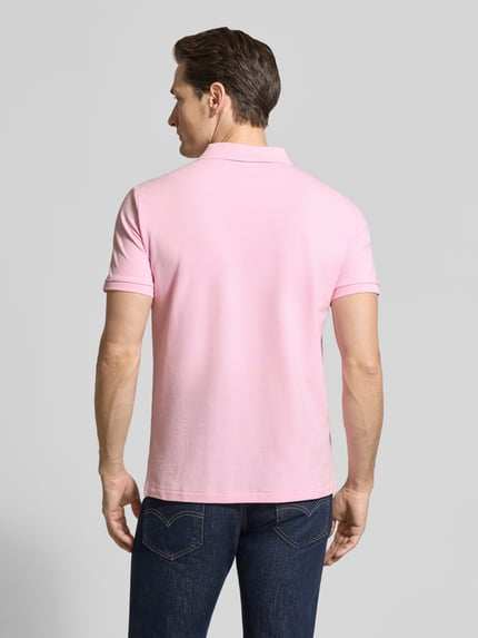 Männermodel trägt Slim Fit Poloshirt aus Baumwoll-Mix von Polo Ralph Lauren in Optik: Unifarben, Materialverarbeitung: Piqué, Ganzkörperansicht Rückansicht.