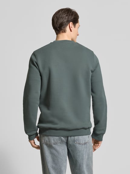 Männermodel trägt Regular Fit Sweatshirt aus reiner Bio Baumwolle Modell 'BAARO FLEECE' von Armedangels, Optik: Unifarben, Ganzkörperansicht Rückansicht.