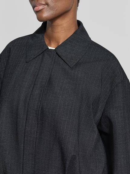 Frauenmodel trägt Regular Fit Blazer mit Drapierungen Modell 'SOUFFLE' von MANGO, Material-Mix Viskose, dunkle Farbe, Nahaufnahme Oberkörper.
