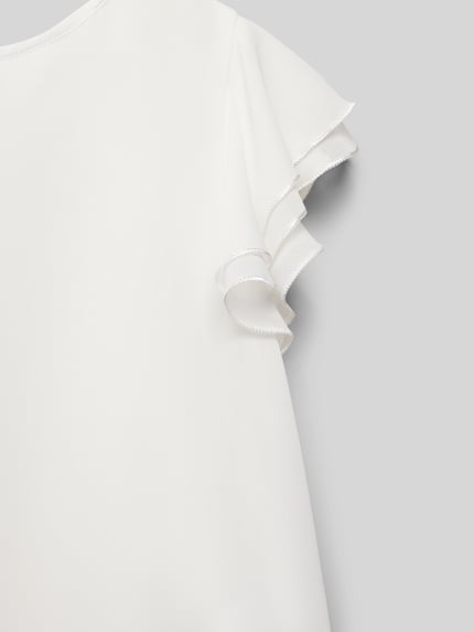 Meisje draagt Regular Fit Blouse met ronde hals van Weise, kapmouwen met ruches, stof met fijne structuur, detailopname mouw.