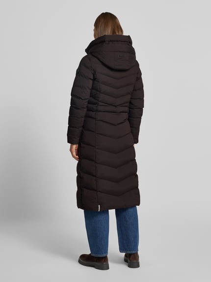 Frauenmodel trägt khujo Steppmantel mit Eingrifftaschen Modell 'INGRAM' in Schwarz, strukturierte Oberfläche, Ganzkörperansicht Rückansicht.