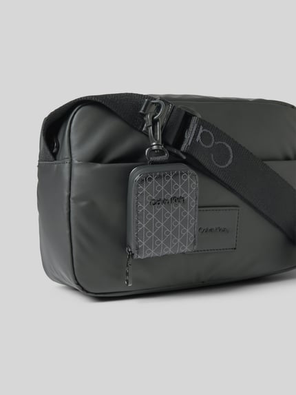 Produktfoto, Handtasche met labelpatch en verstelbare schouderband van CK Calvin Klein, model PUFFER UTILITY CAMERA BAG, zwart, hoofvak met ritssluiting, utility-look, breedte 30 cm, lengte 16 cm, diepte 7 cm, schouderbandlengte 145 cm.