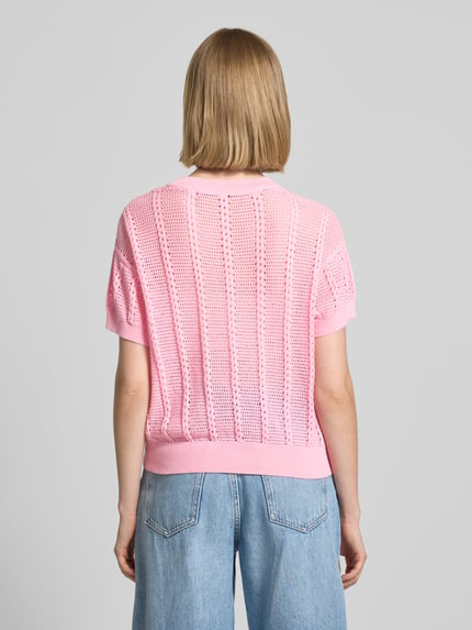 Młodzieżowy model nosi Relaxed Fit Strick-Shirt aus Baumwoll-Mix Modell 'LUX LIGHT' od Vero Moda, różowy, dzianina, ażurowy wzór, bawełniana mieszanka, luźny krój, tył produktu, widok całej sylwetki od tyłu.