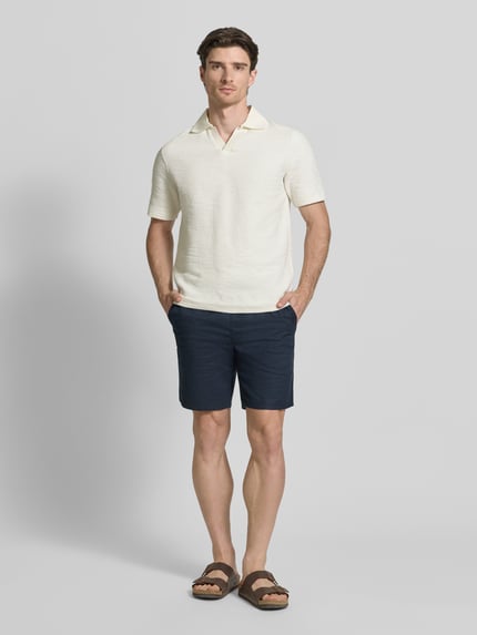 Männermodel trägt Regular Fit Poloshirt mit Polokragen Modell 'SAMAC' von Samsøe Samsøe in Creme, kurzärmelig, Ganzkörperansicht von vorne.