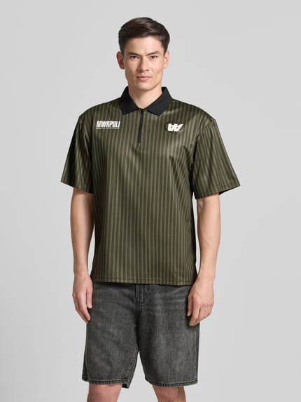 Männermodel trägt Regular Fit Poloshirt mit Label-Print Modell 'Lama' von Wood Wood, grün-schwarze Streifen, Nahaufnahme Oberkörper, Herren Poloshirt, Polokragen, kurzer Reißverschluss, Rückenlänge 72 cm bei Größe M.