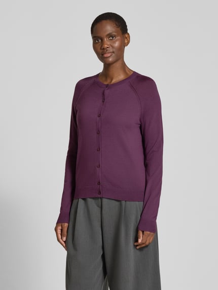 Frauenmodel trägt Strickjacke aus Wolle mit Raglanärmeln von BOSS, unifarben, Feinstrick, Rundhals, Knopfleiste, Ganzkörperansicht von vorne.