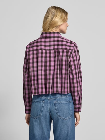 Modelka nosi Cropped Langarmbluse mit Label-Detail od Marc O'Polo, Wzór na całej powierzchni w kratę, wielokolorowa, mankiety, kołnierz, listwa guzikowa, krój krótki, detal z logo, zaokrąglone wykończenie, widok całej sylwetki z tyłu.