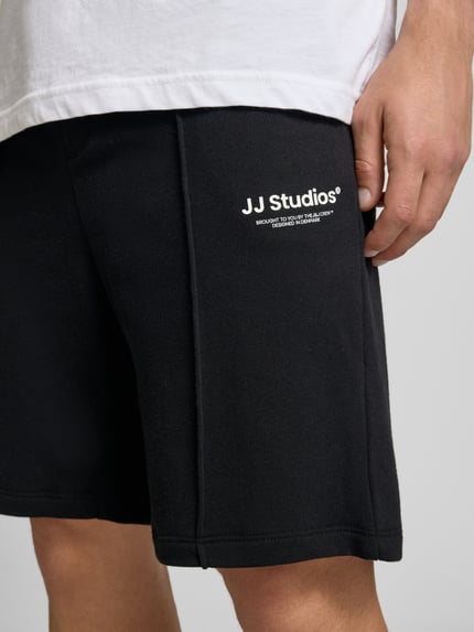 Männermodel trägt Sweatshorts mit Logo Modell 'KANE' von Jack & Jones, Baumwoll-Mix, Relaxed-Fit, Nahaufnahme Oberschenkel.