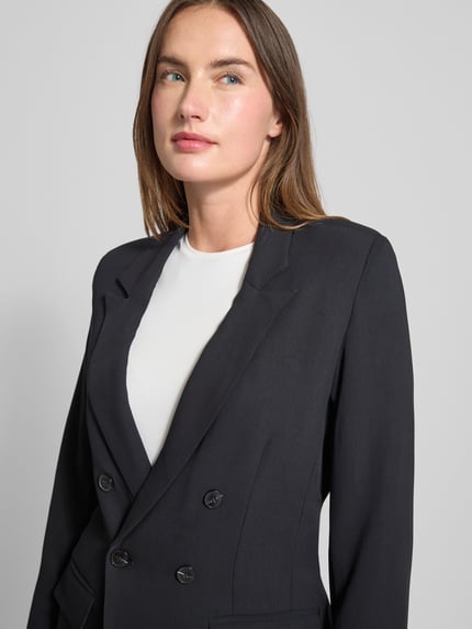 Vrouwenmodel draagt Blazer met Reverskraag Modell 'Inga' van GUIDO MARIA KRETSCHMER WOMAN in zwart, detailopname bovenlichaam.