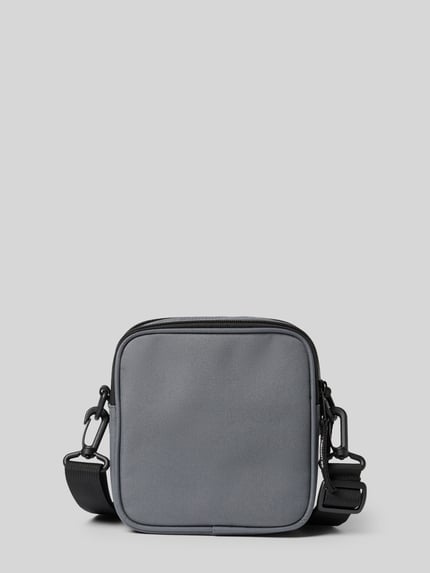 Produktfoto, Crossbody Bag met logopatch van Carhartt Work In Progress in grijs, rechthoekige vorm, gladde textuur, verstelbare schouderband, afneembare schouderband, hoofdvak met ritssluiting, breedte 17 cm, lengte 18 cm, diepte 6 cm, bandlengte 80 cm.