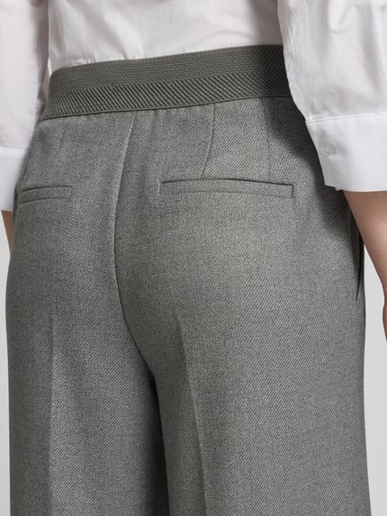 Frauenmodel trägt Regular Fit Hose mit Bundfalten von Betty Barclay in melierter Strukturoptik, Detailaufnahme Rückansicht.
