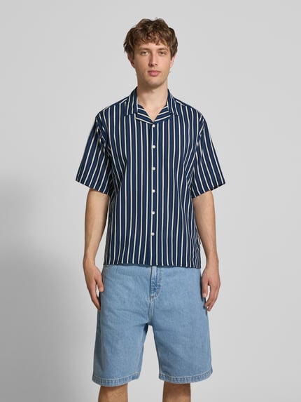 Männermodel trägt Regular Fit Freizeithemd mit Reverskragen Modell 'HOWIE' von Redefined Rebel, Allover-Look, Reine Baumwolle, Ganzkörperansicht von vorne. Rückenlänge 60 cm, Schulterbreite 60 cm, Ärmellänge 30 cm, Label-Detail.