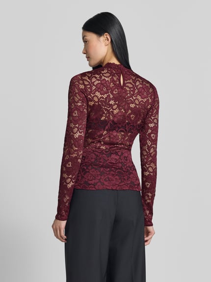 Frauenmodel trägt Slim Fit Longsleeve aus floraler Spitze Modell 'Lacey' von YAS in Dunkelrot, semitransparentes Design, Rückansicht, Ganzkörperansicht Rückansicht.