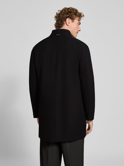 Männermodel trägt Regular Fit Mantel mit Knopf- und Reißverschluss von ROY ROBSON in Schwarz, strukturierte Oberfläche, Ganzkörperansicht Rückansicht. Regular Fit, Stehkragen, Brusttasche, Eingrifftaschen, Rückenlänge 91 cm, Schulterbreite 47 cm, Brustweite 55 cm, Ärmellänge 69 cm.