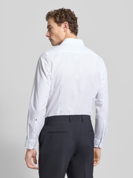 Männermodel trägt Slim Fit Businesshemd aus Popeline von Seidensticker, Unifarbenes-Design, Reine Baumwolle, Ganzkörperansicht Rückansicht.